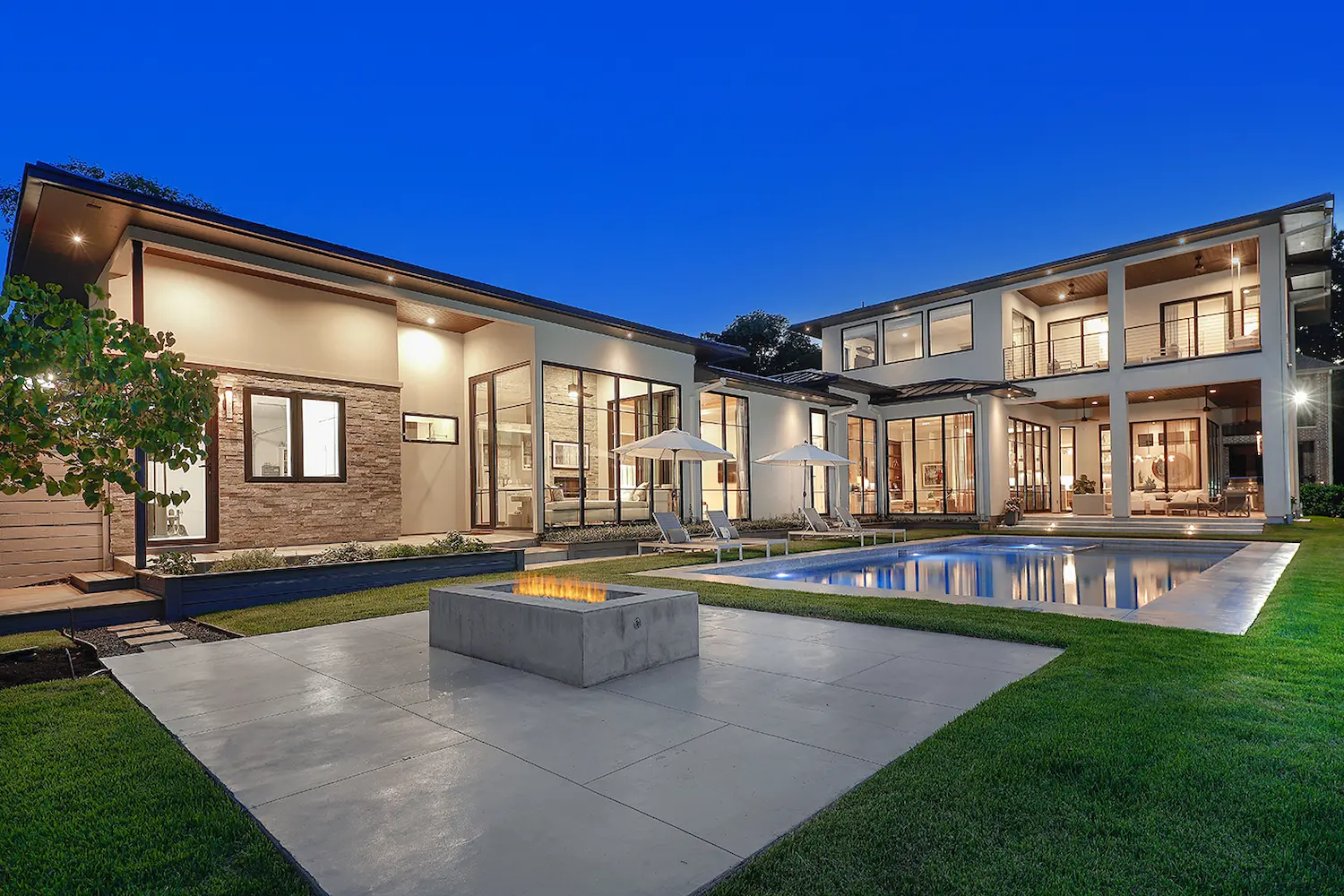 Courtyard pool and twin glass wings at blue hour