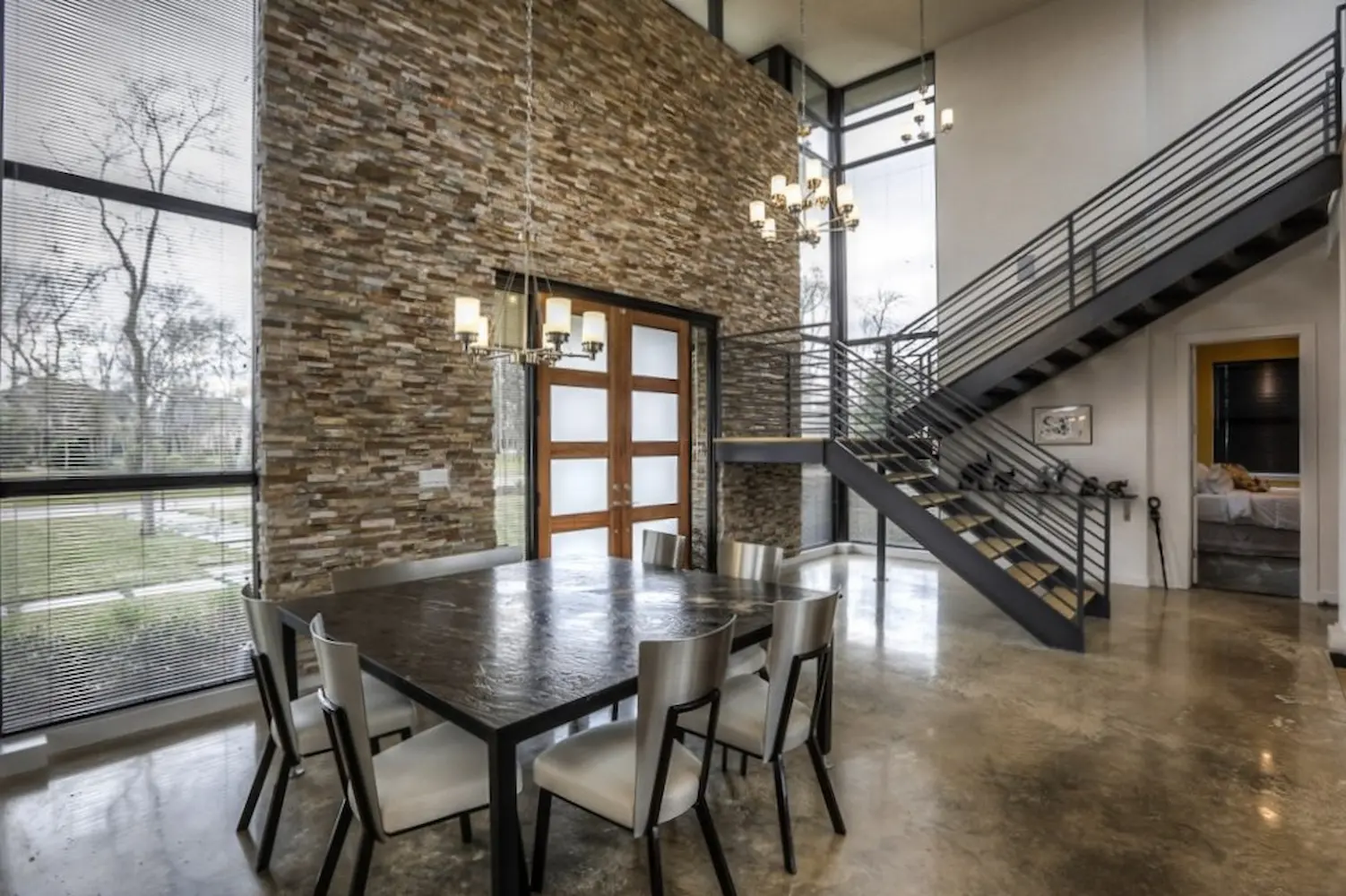 Double-height stone hall with floating steel staircase