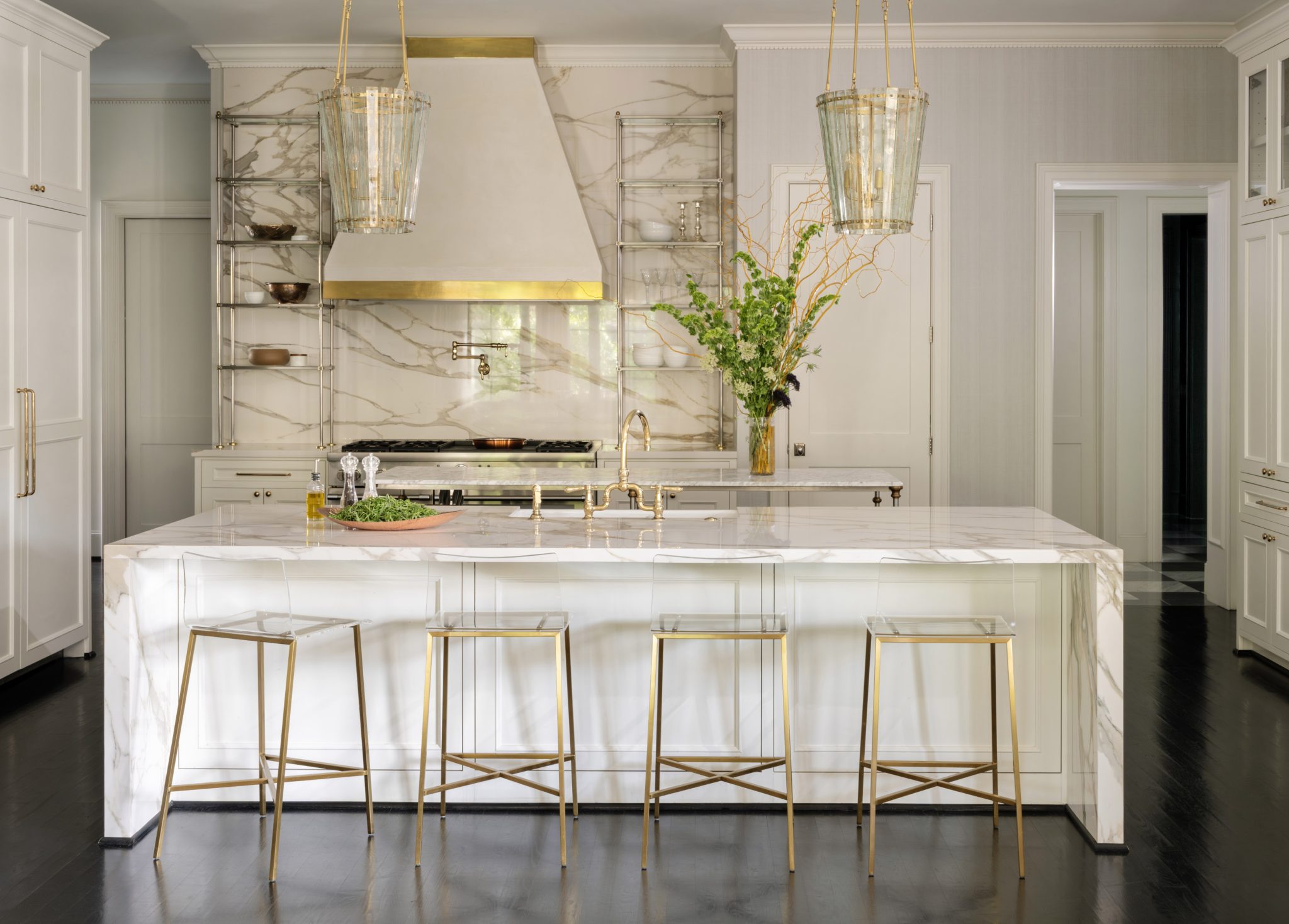Hann kitchen remodel: Calacatta waterfall island, brass rail shelving, plaster hood with a brass band